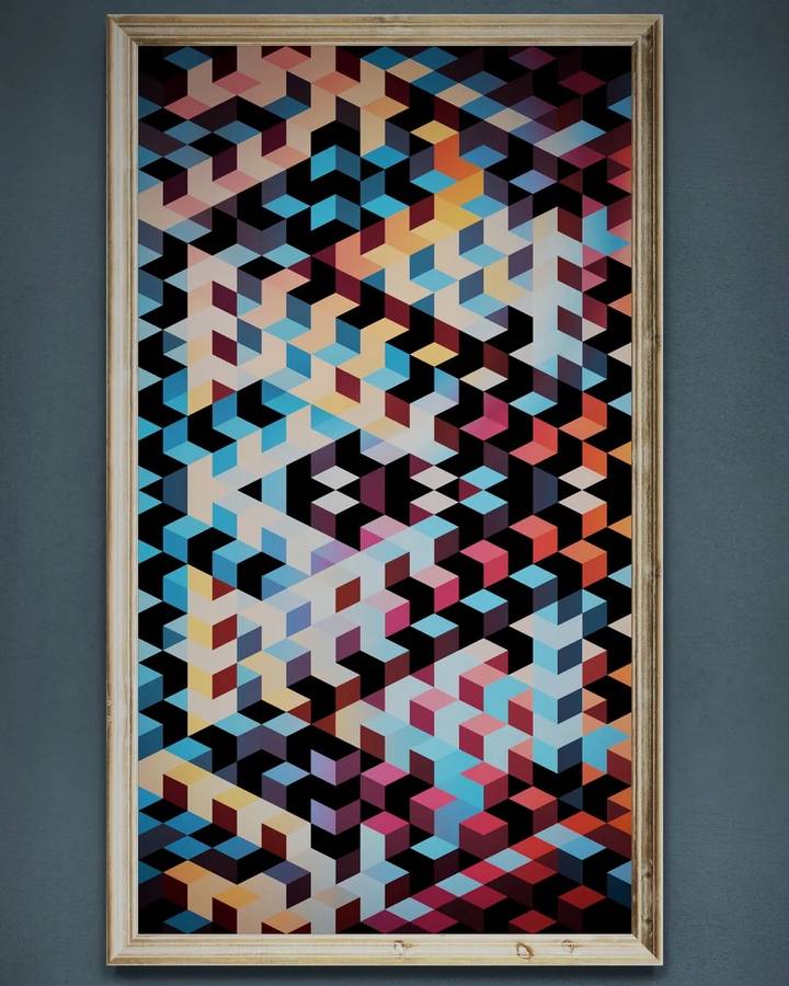 A framed painting of interlocking isometric cubes in blue, red, cream and black, hung on a dark wall.