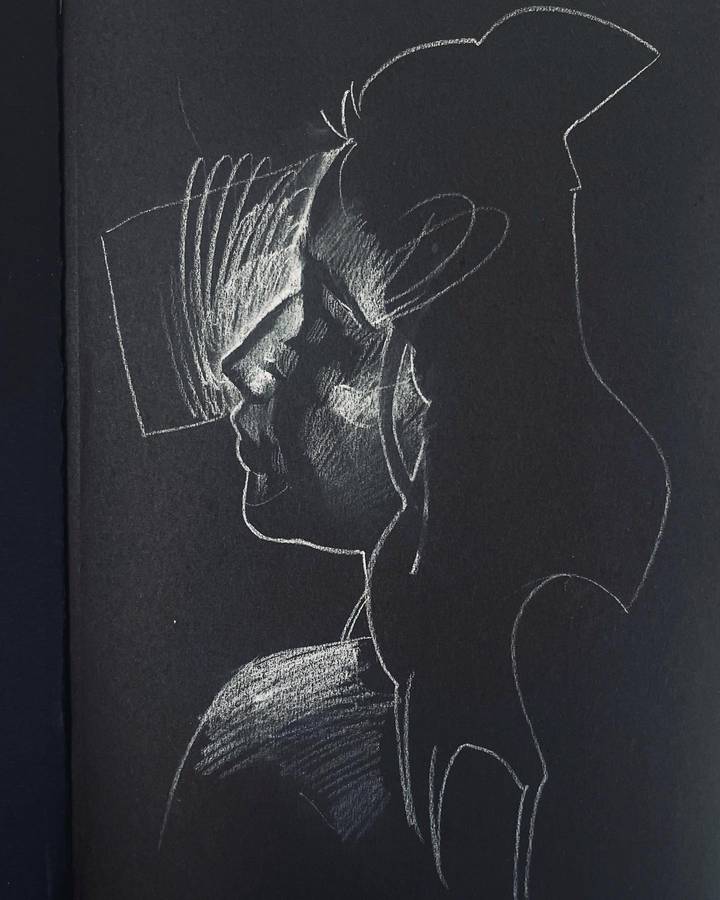 A white chalk drawing on black paper of a head in profile wearing a hat, its shadow thrown behind it.