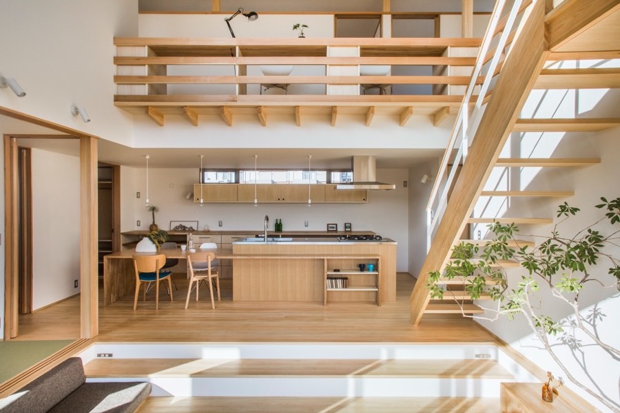 A pale timber interior with a sunken lounge, a double height void and a study balcony above the kitchen.